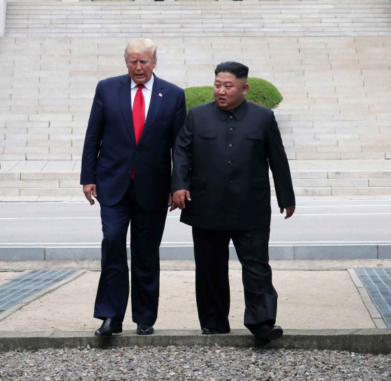 도널드 트럼프 미국 대통령(왼쪽)과 김정은 북한 국무위원장이 6월 30일 경기 파주 판문점에서 만나 군사분계선을 넘어 월북한 뒤 다시 남측으로 내려오고 있다. 뉴시스