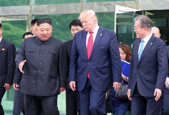 문재인 대통령이 6월 30일 경기 파주 판문점 자유의 집에서 열린 김정은 북한 국무위원장(왼쪽)과 트럼프 미국 대통령(가운데)의 정상회담을 끝내고 나오며 이야기를 나누고 있다. 뉴시스