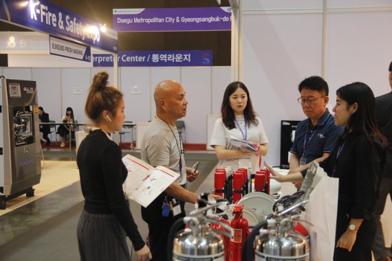 '방콕 한국소방전'의 한국소방기구제작소 홍보부스를 찾은 해외바이어(왼쪽 두번째)가 회사 관계자로부터 제품에 대해 설명을 듣고 있다. 사진=엑스코 제공