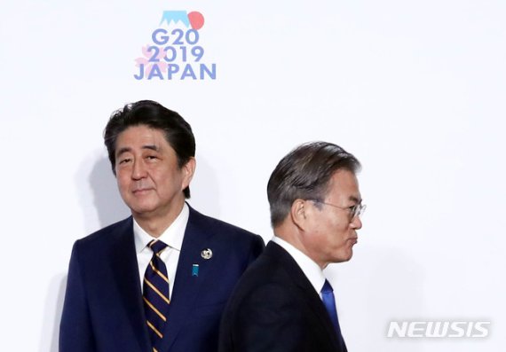 문재인 대통령이 지난 6월 28일 오사카 G20정상회의 공식 환영식에서 아베신조 일본 총리와 가벼운 악수를 나눈 뒤 지나치고 있다. 뉴시스