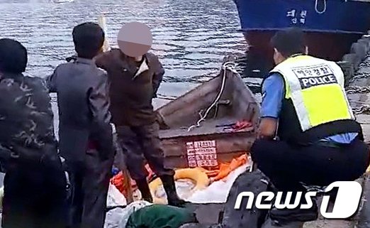 지난 15일 삼척항 부두에 정박한 북한어선과 어민이 경찰에 조사받는 모습. (독자 제공) 2019.6.19/뉴스1