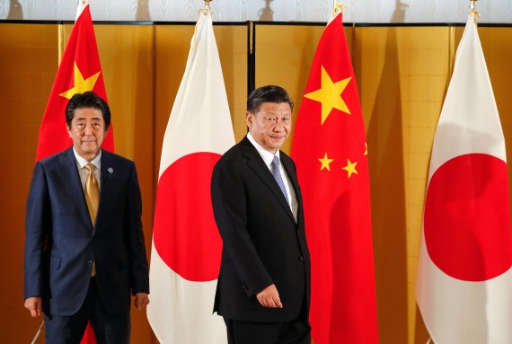 아베 신조 일본 총리가 27일 일본 오사카에서 주요 20개국(G20) 정상회의 참석차 방일한 시진핑 중국 국가주석과 회담을 위해 함께 걸어가고 있다. AP뉴시스.