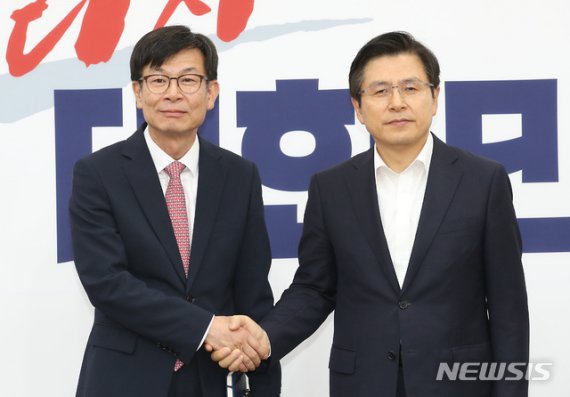 황교안 자유한국당 대표(오른쪽)와 김상조 청와대 정책실장이 5일 서울 국회에서 회동에 앞서 악수를 하고 있다. 뉴시스