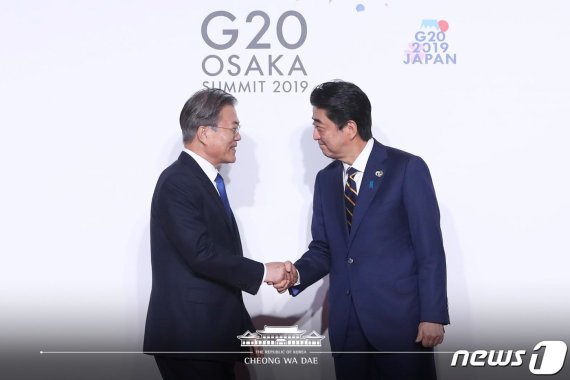 문재인 대통령이 지난달 28일 오사카에서 열린 G20 정상회의 공식환영식에서 의장국인 일본 아베 신조 총리와 악수하고 있다.