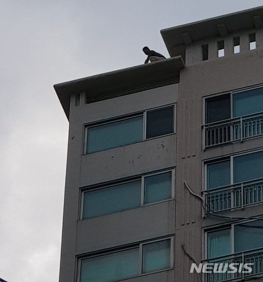 【거제=뉴시스】 경남 거제시 옥포1동 한 아파트 20층 옥상에서 경찰과 대치중인 박모(45)씨 모습. (사진=거제경찰서 제공) /사진=뉴시스