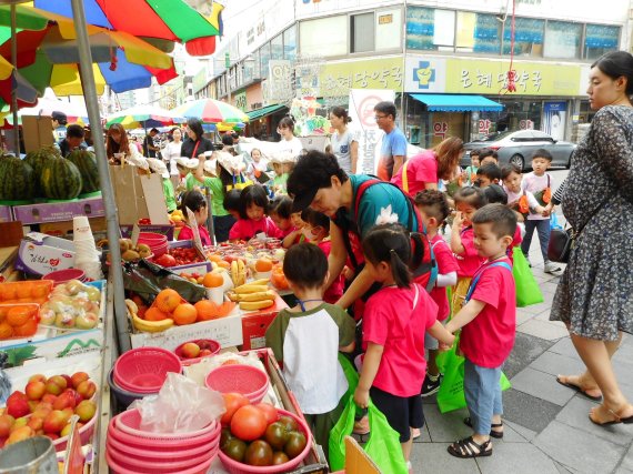 지난 19일 서울 면목동 중랑동부시장에서 진행된 '우리동네 시장나들이' 행사에 참가한 지역 어린이들이 장보기를 체험하고 있다. 중랑동부시장 제공
