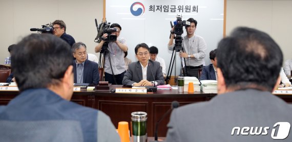 박준식 최저임금위원장과 그 맞은 편에 앉은 근로자위원과 사용자위원. 2019.7.11/뉴스1