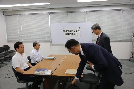 12일 도쿄 지요다구 소재 일본 경제산업성에서 열린 일본의 수출규제와 관련한 한일 실무협의에 우리 측 담당자들이 도착, 자리에 착석하고 있다. 일본 측 담당자들은 자리에서 일어나지 않은 채 굳은 표정으로 정면을 응시하고 있다. 사진=공동취재단