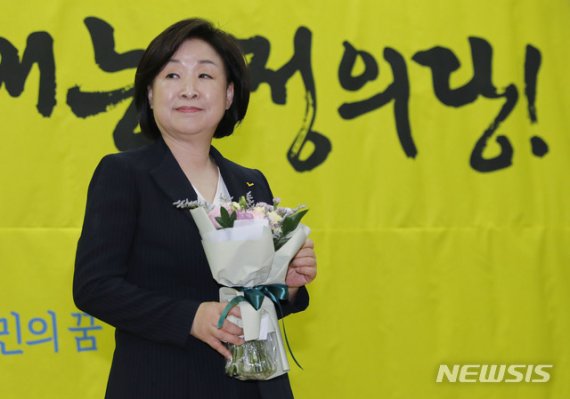 정의당 제5기 당대표에 선출된 심상정 대표가 지난 13일 서울 여의도 국회의원회관에서 꽃다발을 받고 있다.