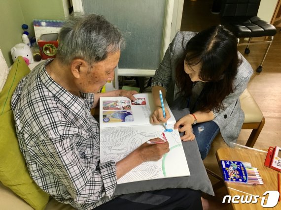 허옥임 간호사가 치매 어르신에게 색칠공부를 알려주고 있다.(용인시 제공) © News1 김평석 기자