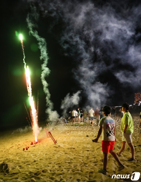 지난 1일 강릉 경포해변에서 관광객이 폭죽을 터트리자 불꽃과 연기가 피어오르고 있다.2019.08.01/뉴스1 © News1 이찬우 기자