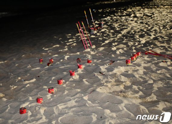 지난 1일 강릉 경포해변에서 관광객들이 쓰고 버린 폭죽이 그대로 꽂혀 있다.2019.08.01/뉴스1 © News1 이찬우 기자