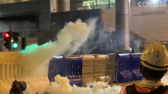 지난해 8월 5일 홍콩 완차이 지역 경찰 본부 앞에서 민주화 시위대가 경찰이 쏜 연막탄을 주워 다시 던진 뒤 이를 바라보고 있다.로이터뉴스1