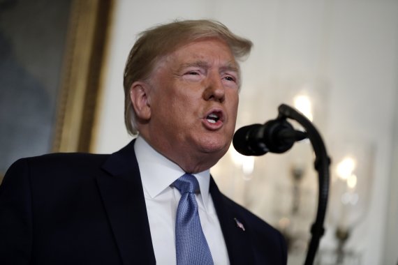 In this Aug. 5, 2019, photo, President Donald Trump speaks about the mass shootings in El Paso, Texas and Dayton, Ohio, in the Diplomatic Reception Room of the White House in Washington. As Trump attempts to return to the role of national unifier after yet another set of shooting tragedies, his effo