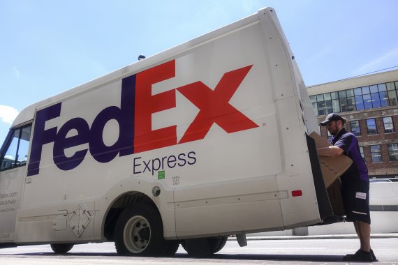 FILE - In this June 25, 2019, file photo a FedEx delivery truck is loaded by an employee on the street in downtown Cincinnati. FedEx is severing another tie with Amazon as the online powerhouse continues to strengthen its own shipping capabilities. (AP Photo/John Minchillo, FIle) /뉴시스/AP /사진=