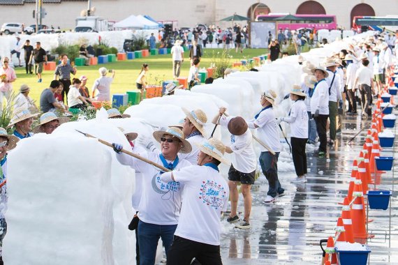 지난 10일 서울 광화문 광장에서 크라운해태 임직원 300여명이 '2019 한여름밤의 눈조각전'에 전시할 작품을 만들고 있다. 크라운해태 제공