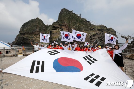 10일 경상북도 독도를 찾은 멀티암벽 산악회(대장 이재석, 엄재선, 차금호, 박경모) 오윤숙을 비롯한 대원들이 시민들과 함께 독립운동가 의복을 입고 태극기를 흔들며 '한·일 경제위기&경제왜란, 하나되어 이겨냅시다' 퍼포먼스를 펼치고 있다. 2019.8.10/뉴스1 © News1 박세연 기자