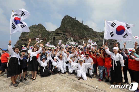 10일 경상북도 울릉군 독도를 찾은 멀티암벽 산악회(대장 이재석, 엄재선, 차금호, 박경모) 오윤숙을 비롯한 대원들이 독립운동가 의복을 입고 시민들과 함께 태극기를 흔들며 '한·일 경제위기&경제왜란, 하나되어 이겨냅시다' 퍼포먼스를 펼치고 있다. 2019.8.10/뉴스1 © News1 박세연 기자
