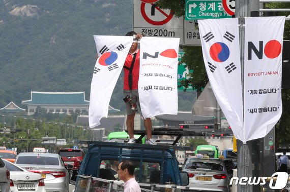 6일 오전 서울 중구 세종대로 일대에서 중구청 관계자들이 태극기와 '노 재팬' 배너깃발을 설치하고 있다. © News1 민경석 기자