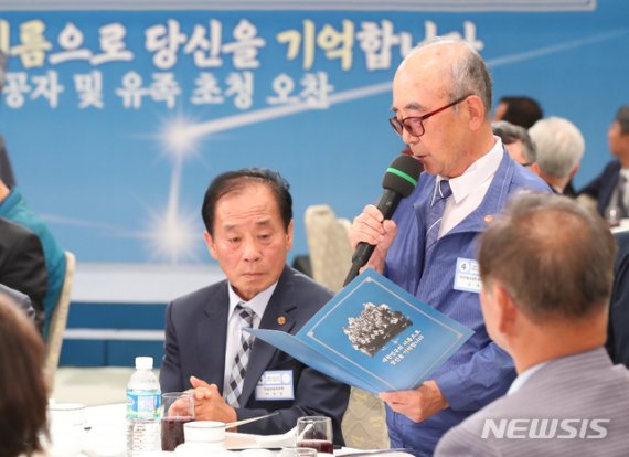 【서울=뉴시스】전신 기자 = 심명철 지사 아들 문수일 씨가 13일 청와대 영빈관에서 열린 독립유공자 및 후손 초청 오찬에서 여옥사 8호 감방의 노래가사를 공개하고 있다. 2019.08.13. photo1006@newsis.com