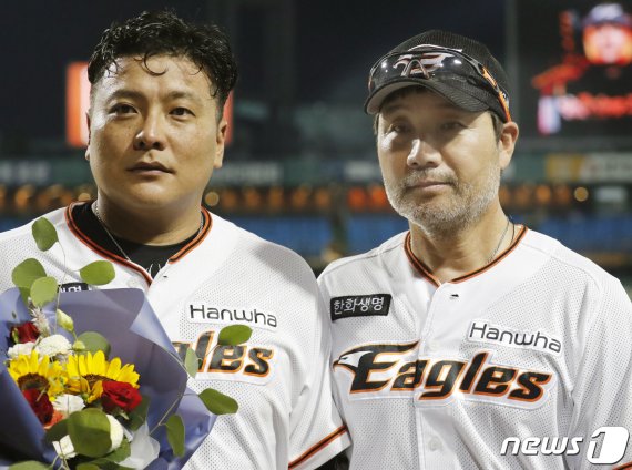 13일 오후 대전 한화생명 이글스파크에서 열린 프로야구 2019 신한은행 MY CAR KBO리그 한화 이글스와 NC 다이노스 경기 중 8회말 공격에 앞서 한화 한용덕 감독이 김태균에게 1000득점 축하 꽃다발을 전달하고 있다. 김태균은 이날 역대 14번째로 1000득점을 기록했다. 2019.8.13/뉴스1 © News1 주기철 기자