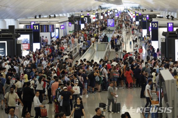 【홍콩=AP/뉴시스】12일(현지시간) 홍콩 국제공항 출국장에 여행객들이 몰려들어 출국편 운항 정보를 확인하고 있다. 홍콩 국제공항은 이날 성명을 통해 5천여 명의 시위대가 공항에 모여 이로 인해 공항 운영이 “심각하게 방해"됐다며 홍콩발 항공편에 대한 모든 탑승 수속 서비스를 중단했다. 2019.08.12.