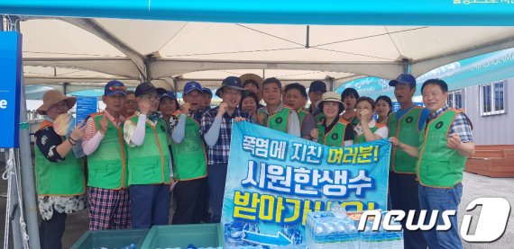 광주 서구 지역자율방재단이 폭염피해 예방 캠페인 일환으로 시민들에게 생수를 나눠주고 기념사진을 찍고 있다.2019.8.14/뉴스1 © News1