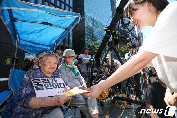 14일 서울 종로구 중학동 옛 일본대사관 앞에서 열린 제1400차 일본군 성노예제 문제 해결을 위한 정기 수요시위에서 길원옥 할머니가 광주 조선대학교 부속 여자고등학교 학생들의 편지를 받고 있다. 2019.8.14/뉴스1 © News1 박정호 기자