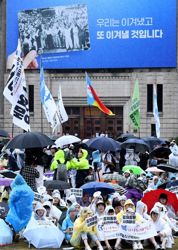 빗속에 울려퍼진 "아베 규탄"/광복절인 15일 오전 서울 세종대로 서울광장에서 열린 광복 74주년 일제 강제동원 문제 해결을 위한 시민대회 및 국제평화행진에서 참가자들이 피켓을 들고 있다. 사진=김범석 기자