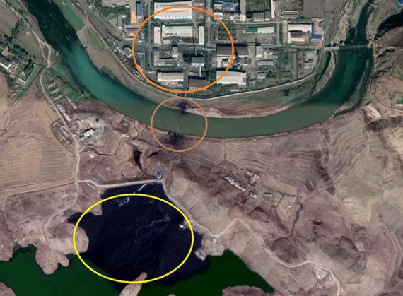 【서울=뉴시스】북한 평산의 우라늄 공장 일대를 찍은 위성사진. 위쪽에 공장 시설들이 있고, 파이프로 연결된 아래 저수지의 물이 검게 변색돼있다. 미국의 북한 분석가 제이컵 보글은 15일 자유아시아방송과의 인터뷰에서, 우라늄 공장에서 나온 폐기물이 주변을 오염시키고 있는 것으로 보인다고 주장했다. <사진출처:자유아시아방송> 2019.08.16