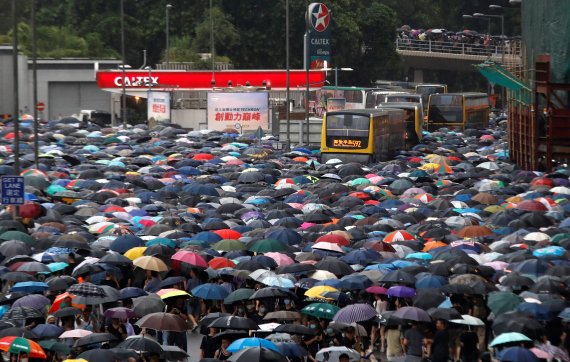 지난 18일 홍콩에서 '범죄인 인도법(송환법)'에 반대하는 시위대가 우산을 들고 행진하고 있다.로이터뉴스1