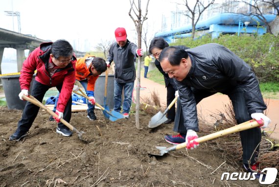 유동균 마포구청장(오른쪽 첫번째) 등 참석자들이 지난 3월 서울 마포대교 하부 한강공원에서 열린 제74회 식목일 나무심기 행사에서 식재작업을 하고 있다. 사진=뉴스1