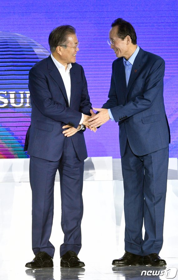 문재인 대통령이 20일 오후 전북 전주시 효성 탄소섬유 전주공장에서 열린 전라북도와 전주시, 효성첨단소재와의 투자협약식에 참석해 기념촬영을 마친 뒤 송하진 전북도지사와 손을 잡으며 이야기를 나누고 있다. 효성은 이날 핵심소재 안보자원화 등을 목표로 2028년까지 총 1조원을 투자해 현재 1개 2000톤 규모의 탄소섬유 생산라인을 10개 2만4000톤까지 증설하기로 했다.(전북사진기자단) 2019.8.20 /뉴스1 © News1 문요한 기자