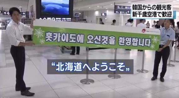 홋카이도 지방자치단체 관계자들이 지난 19일 한국어로 환영인사가 적힌 현수막을 내걸고 한국인 관광객들을 맞이하고 있다. 뉴스1