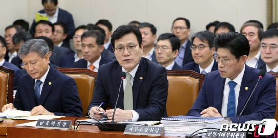 최종구 금융위원장(가운데)이 22일 서울 여의도 국회에서 열린 전체회의에서 의원질의에 답변하고 있다.