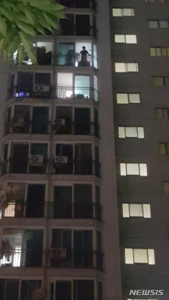 (사진설명= 119구급대원이 아파트 11층에서 10층을 살피고 있다)
