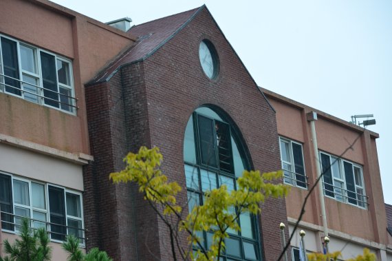 27일 검찰이 조국 법무부 장관 후보자를 둘러싼 의혹과 관련해 경남 진해 웅동학원에서 압수수색을 진행하고 있는 가운데 웅동중학교 학생이 창문을 통해 밖을 내다보고 있다. 뉴시스