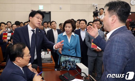 국회 정치개혁특별위원회가 패스트트랙에 올라있는 공직선거법 개정안을 29일 의결했다. 한국당 나경원 원내대표(왼쪽 세 번째)와 장제원 한국당 의원(왼쪽 두 번째)이 홍영표 정개특위 위원장(왼쪽 첫 번째) 앞으로 뛰쳐나와 항의하고 있다. 이날 한국당 의원들은 정개특의 의결에 대해 "역사의 죄인"이라며 비판했다. 뉴스1