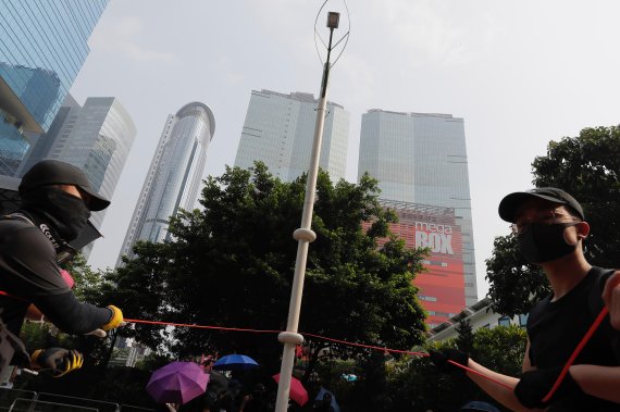 Demonstrators try to pull down a smart lamppost during a protest in Hong Kong, Saturday, Aug. 24, 2019. Chinese police said Saturday they released an employee at the British Consulate in Hong Kong as the city's pro-democracy protesters took to the streets again, this time to call for the removal of 