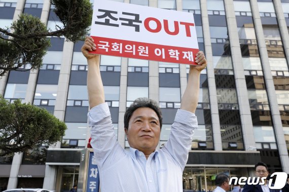 이학재 자유한국당 의원이 2일 서울 종로구 조국 법무부 장관 후보자 사무실 앞에서 '조국 OUT'이라고 적힌 팻말을 들고 있다. 뉴스1