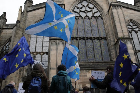 Protesters holding Scottish and European flags gather in front of St Gilles Cathedral facing the Scottish Court of Session in Edinburgh, Scotland, Wednesday, Sept 4, 2019. A Scottish court says British Prime Minister Boris Johnson's planned suspension of Parliament is lawful. The closely watched dec