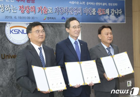 한국지엠 군산공장을 인수한 MS컨소시엄의 대표기업인 ㈜명신과 전북도‧군산시의 투자협약식이 지난 6월 군산대학교 산학협력관에서 열렸다. 사진은 송하진 도지사(가운데), 박호석 ㈜명신 부사장(왼쪽), 강임준 군산시장이 협약서를 들고 기념촬영을 하는 모습. (전북도제공)2019.06.19/뉴스1 © News1 김동규 기자