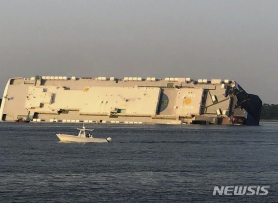 【브런즈웍=AP/뉴시스】8일(현지시간) 미 조지아주 브런즈웍항 인근 해상에서 현대글로비스 소속 대형 자동차 운반선(PCC) '골든 레이' 호가 전도돼 옆으로 누워 있다. 이 선박에 승선한 24명 중 한국인 포함 20명이 대피하거나 구조됐으며 기관실에 있는 것으로 알려진 나머지 한국인 4명에 대해서 구조 작업이 진행 중이다. 2019.09.09.