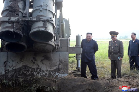김정은 북한 국무위원장(왼쪽 첫번째)이 10일 평안남도 개천 일대에서 실시된 다연장 로켓 시험사격을 현지지도하면서 웃고 있다.로이터뉴스1