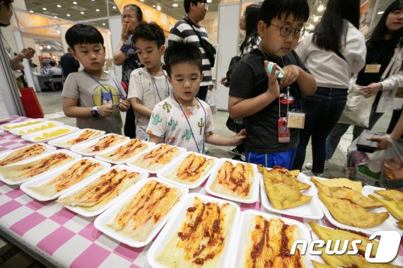 8일 오후 서울 강남구 코엑스에서 열린 '2018 라면박람회'를 찾은 관람객들이 북한 음식인 인조고기밥을 살펴보고 있다. 2018.6.8/뉴스1 © News1 이승배 기자