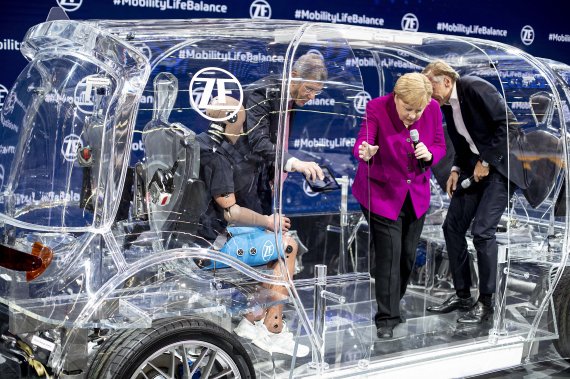 German Chancellor Angela Merkel climbs out of a transparent car with security devices during her visit to the IAA Auto Show in Frankfurt, Germany, Thursday, Sept. 12, 2019. (AP Photo/Michael Probst) /뉴시스/AP /사진=