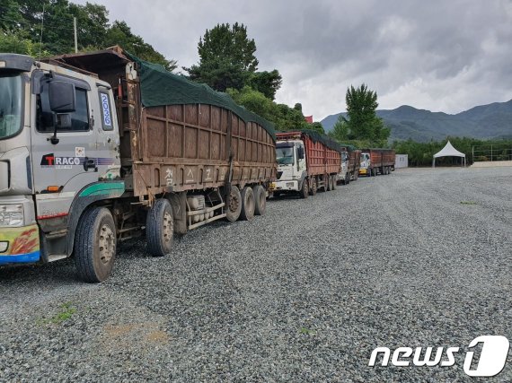 지난 7일 경기도 평택에서 100여톤의 산업폐기물을 적재한 25톤 윙바디 트럭 4대가 충북 충주시 동량면 하천리 충주호리조트에 폐기물 불법투기를 위해 줄지어 서있다. /© 뉴스1