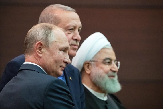 블라디미르 푸틴 러시아 대통령(왼쪽)과 레제프 타이이프 에르도안 터키 대통령(가운데), 하산 로하니 이란 대통령이 16일(현지시간) 터키 앙카라에서 열린 3국 정상회담 후 나란히 걷고 있다. 로이터 뉴스1