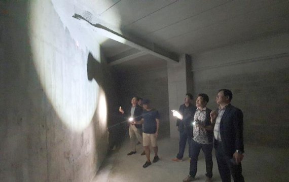 지난 6일 부산 강서구 구의회 의원들이 부산 강서구 명지 신도시의 한 아파트 지하 4층 주차장에서 발생한 H-빔 휨 변형 현상을 살펴보고 있다.
