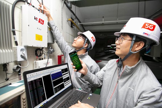 KT 네트워크부문 직원들이 서울 서초구의 한 건물 내 지하 주차장에서 '5G 스마트 빔 패턴 동기화 기술'이 적용된 5G RF 중계기의 품질을 점검하고 있다. KT 제공